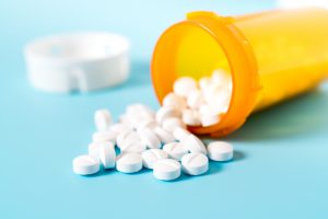 Medication bottle with pills pouring out.